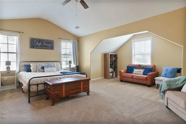 This spacious bedroom offers ample natural light and comfortable carpeting, creating a serene retreat.