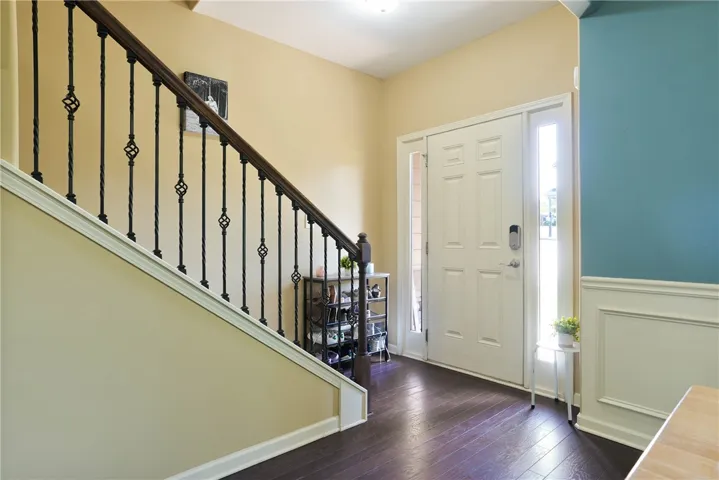 This inviting entrance features elegant hardwood floors and wainscoting.