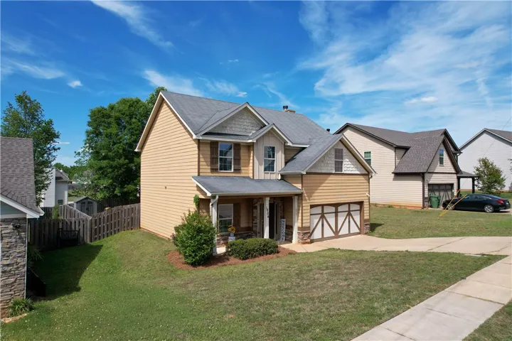 This charming residence features a well-maintained lawn and a welcoming front facade.