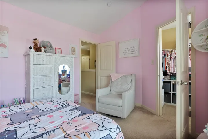 This cozy bedroom offers soft lighting and plush carpet, creating a peaceful personal retreat.