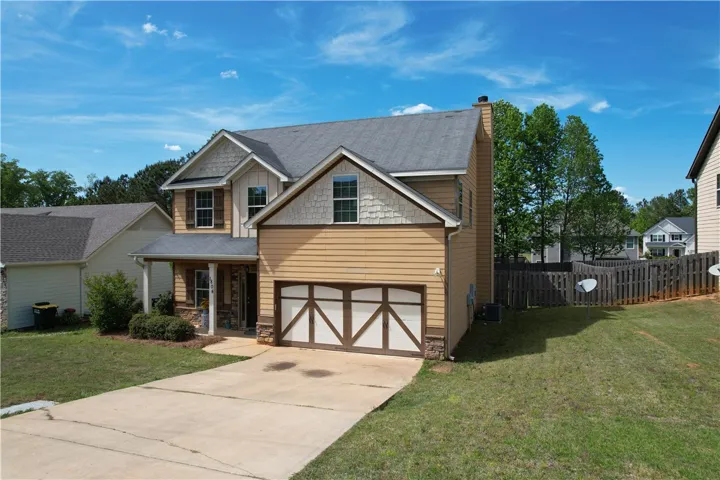 This inviting home presents a classic facade with a welcoming covered entrance and integrated garage.