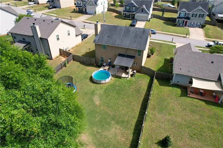 This spacious backyard oasis features an above-ground pool and ample room for outdoor activities.