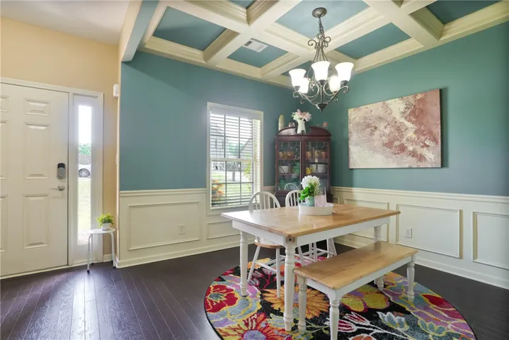 This inviting dining room features a distinctive coffered ceiling and elegant wainscoting.