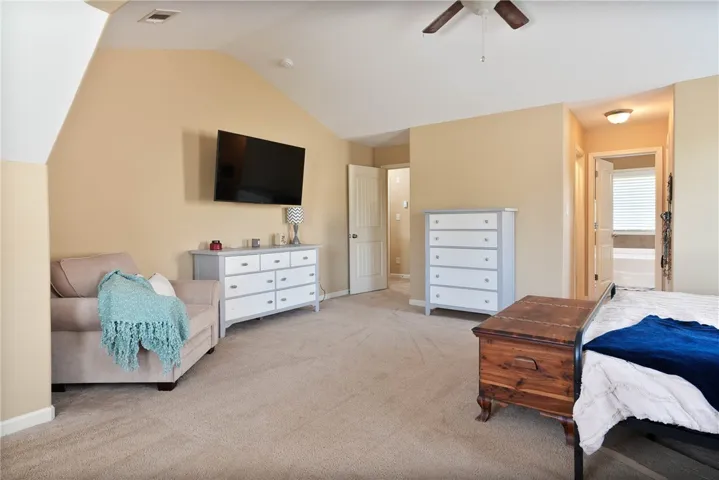 This spacious bedroom features a vaulted ceiling and direct access to an en-suite bathroom.