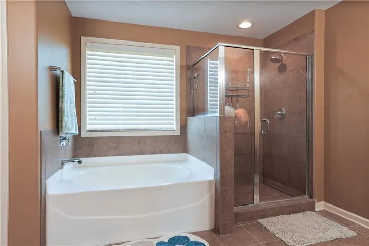 This bathroom features a deep soaking tub and a tiled shower for ultimate relaxation.