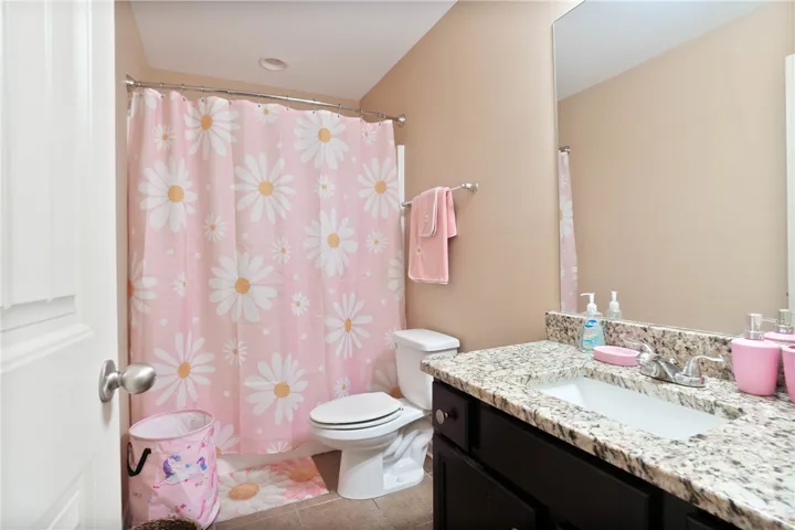 This bathroom features granite counters and tiled flooring for a refined finish.