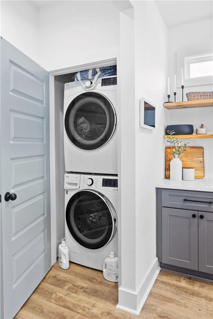 A dedicated utility space features convenient stacked laundry appliances and practical cabinetry.