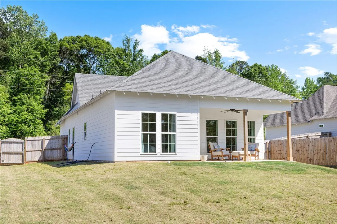 A well-maintained lawn stretches towards a home with a inviting patio, ideal for outdoor leisure.
