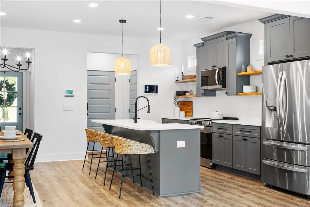 A streamlined kitchen design features sleek cabinetry, stainless steel appliances, and a central island.