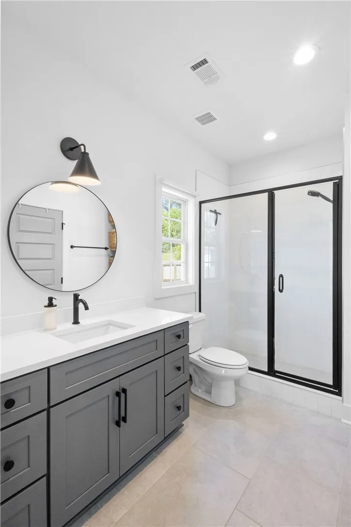 A well-appointed bathroom with a spacious vanity and a clear glass-enclosed shower.