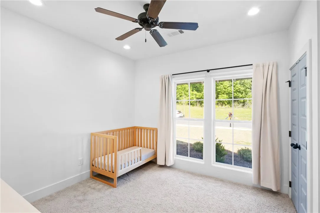 An airy bedroom with dual windows offers abundant natural light and a comforting atmosphere.