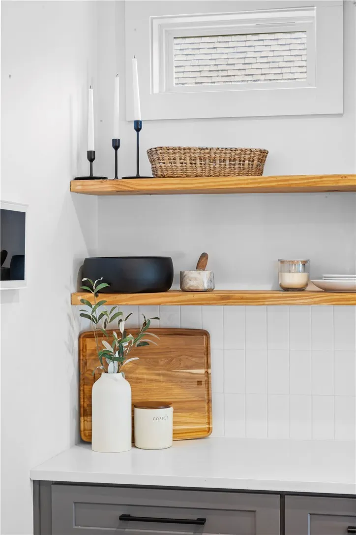 Custom cabinetry and floating wood shelves create an elegant and practical kitchen design.
