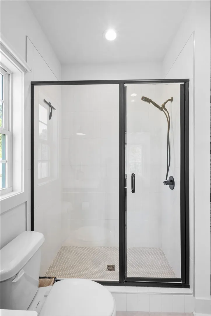 A well-appointed shower space, complete with sleek dark-framed glass doors and contemporary fixtures.