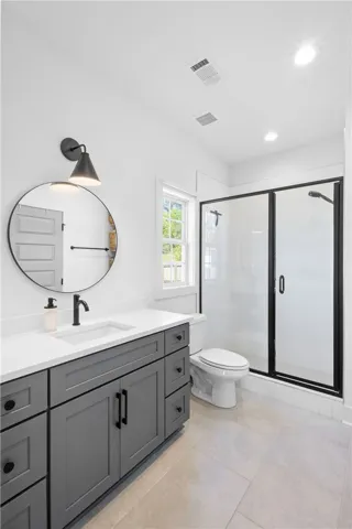 A well-appointed bathroom with a spacious vanity and a clear glass-enclosed shower.