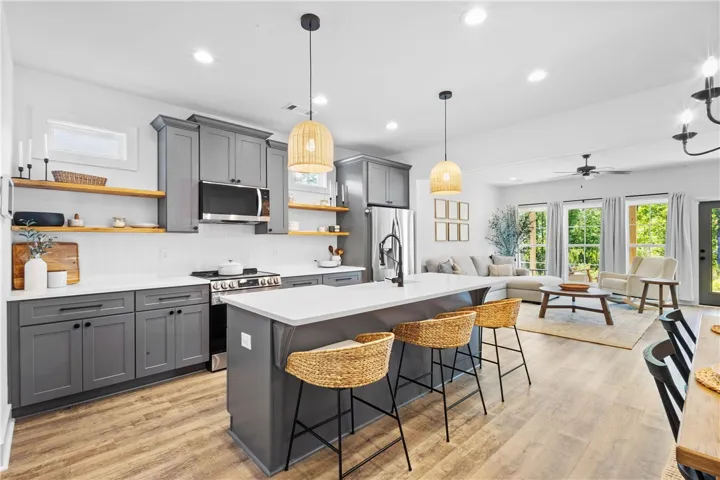 An open-concept living space integrates a stylish kitchen with an inviting living area, perfect for entertaining.