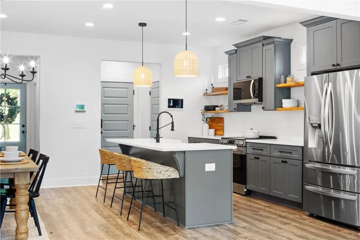 A streamlined kitchen design features sleek cabinetry, stainless steel appliances, and a central island.