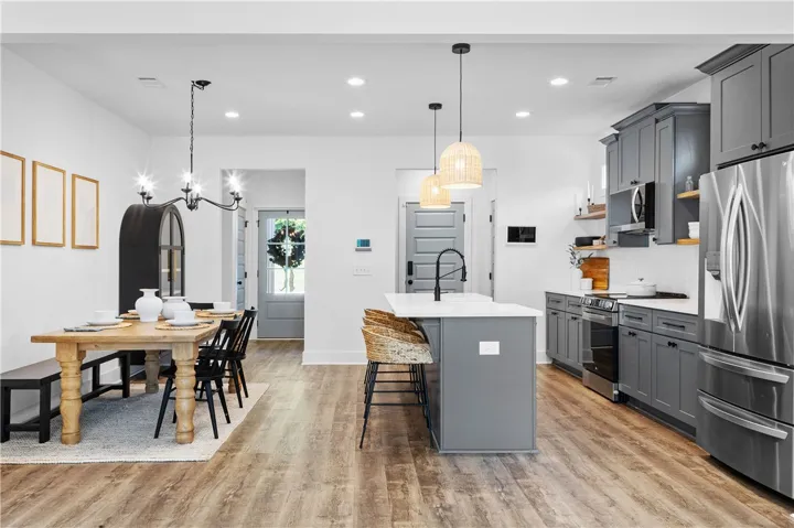 An open-concept living space presents a modern kitchen and a cozy dining area.