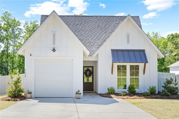 This charming residence features a classic facade with a welcoming entrance and ample parking.