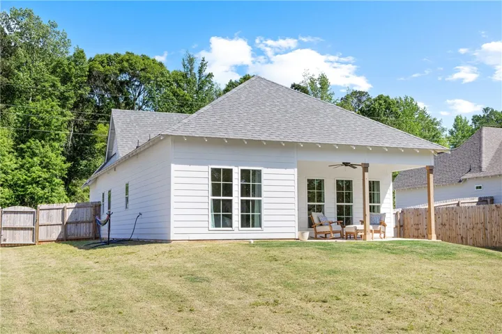 A well-maintained lawn stretches towards a home with a inviting patio, ideal for outdoor leisure.