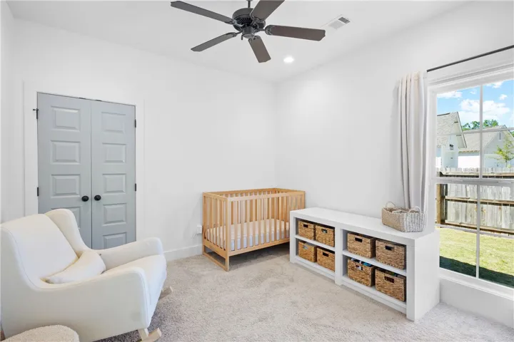 A comforting nursery with soft carpeting and ample natural light, ideal for peaceful moments.