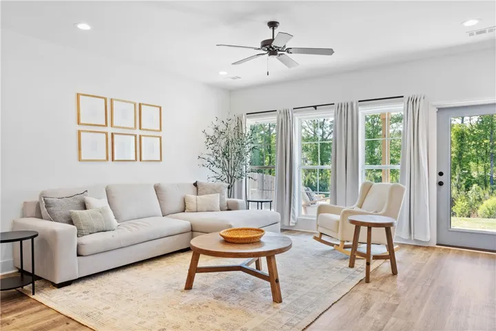 A welcoming living area with rich wood flooring and ample natural light invites relaxation.