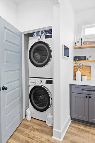 A dedicated utility space features convenient stacked laundry appliances and practical cabinetry.