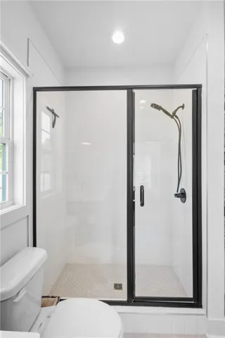 A well-appointed shower space, complete with sleek dark-framed glass doors and contemporary fixtures.