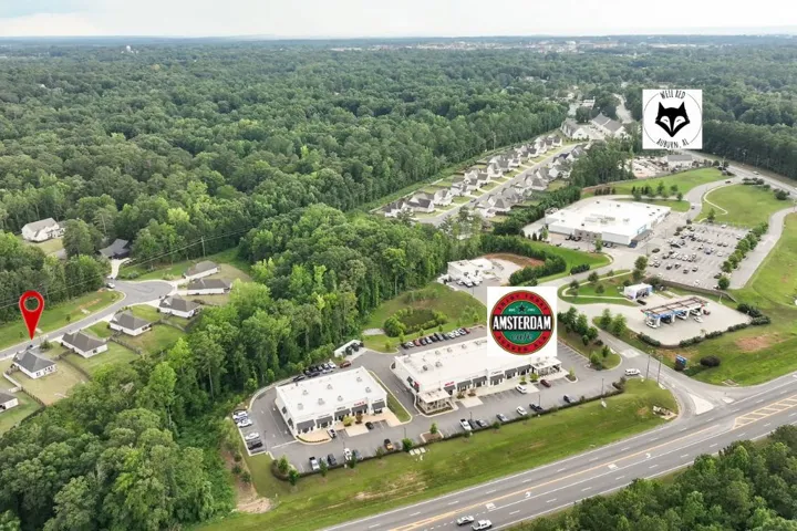 An aerial perspective reveals a vibrant community with convenient commercial access and verdant surroundings.