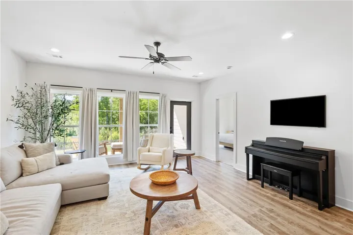 An inviting gathering space offers rich wood-toned flooring and expansive views to the outdoors.