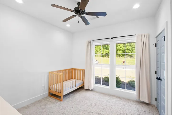An airy bedroom with dual windows offers abundant natural light and a comforting atmosphere.