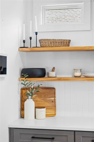 Custom cabinetry and floating wood shelves create an elegant and practical kitchen design.