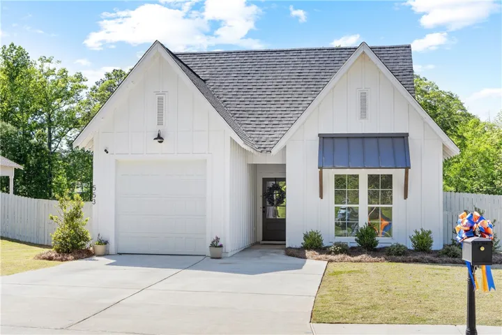 A charming modern farmhouse facade with a welcoming entry and a manicured landscape.