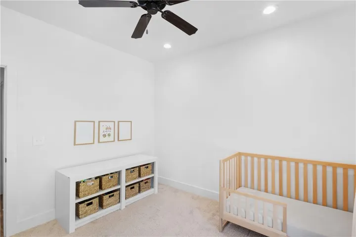 A well-lit room with recessed lighting and a ceiling fan, offering a neutral backdrop for any decor.