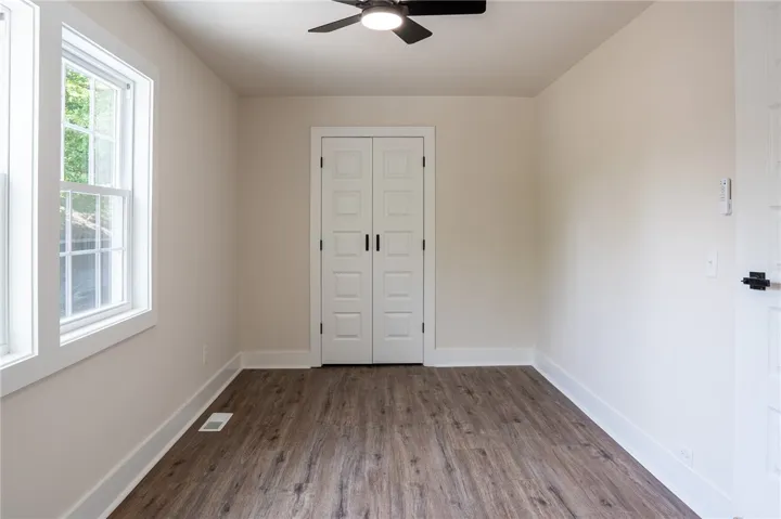 This bright room features a clean design with rich flooring, offering a versatile space.