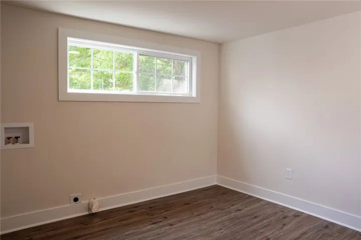 This bright space features durable flooring and a window with verdant outdoor views.