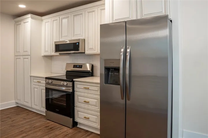 This modern kitchen features pristine cabinetry, sleek countertops, and essential appliances for comfortable living.