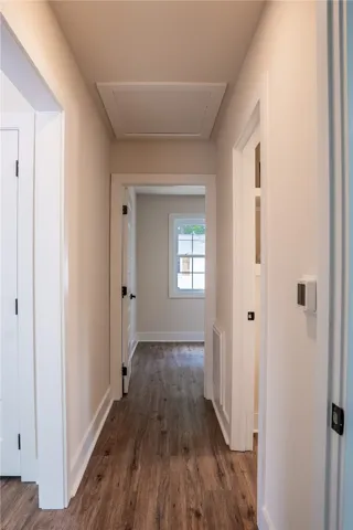 This interior hallway features beautiful wood flooring, offering a seamless flow through the living space.