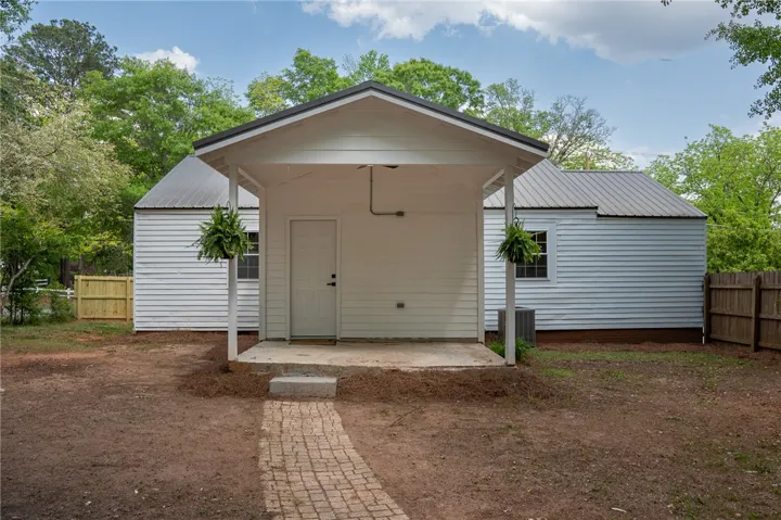 This charming home offers a simple yet inviting exterior with a covered porch.