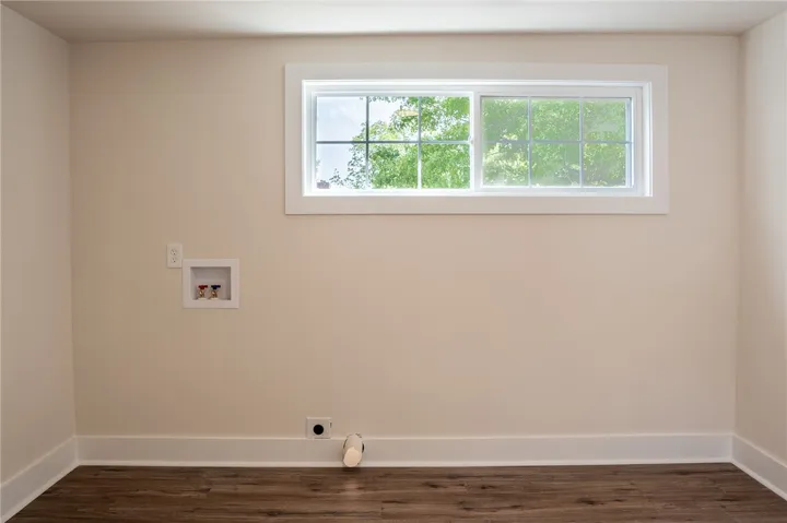 This spacious laundry room offers convenience and natural light through its well-placed window.
