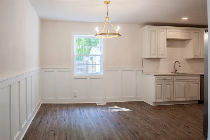 This bright dining area features elegant wainscoting and durable flooring.