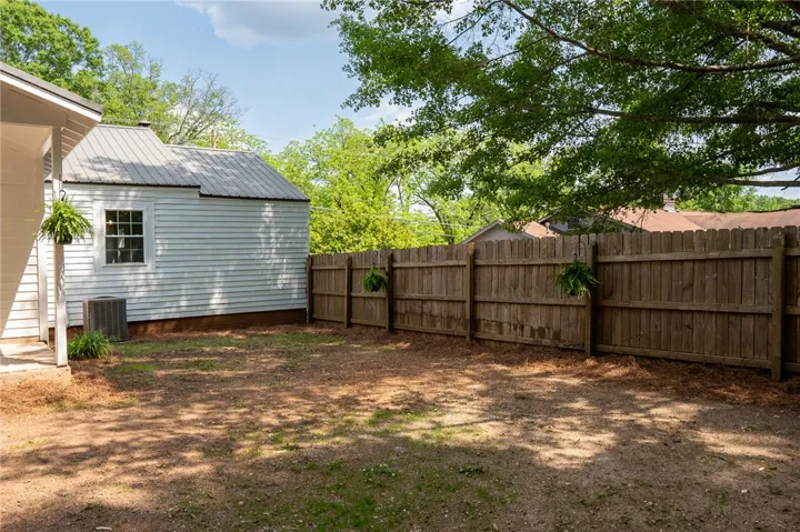 This spacious yard features a practical shed and a privacy fence, perfect for outdoor activities.