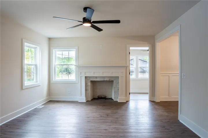 This bright living space features hardwood flooring and a classic fireplace.