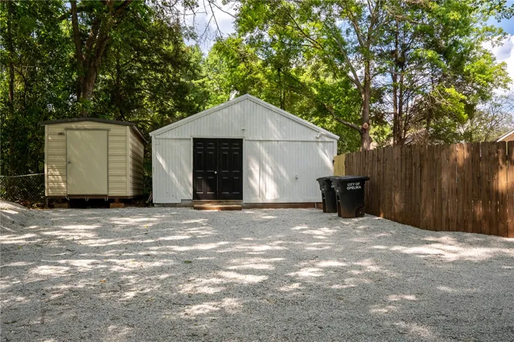 This private yard offers versatile utility buildings and a convenient gravel parking area.