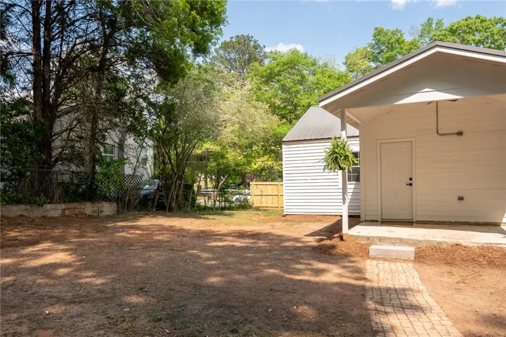 This spacious yard offers ample outdoor living potential, featuring a charming side patio and a versatile shed.