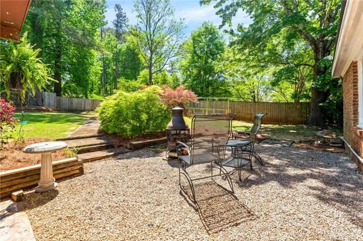 This spacious backyard features a charming gravel patio, perfect for outdoor enjoyment and relaxation.