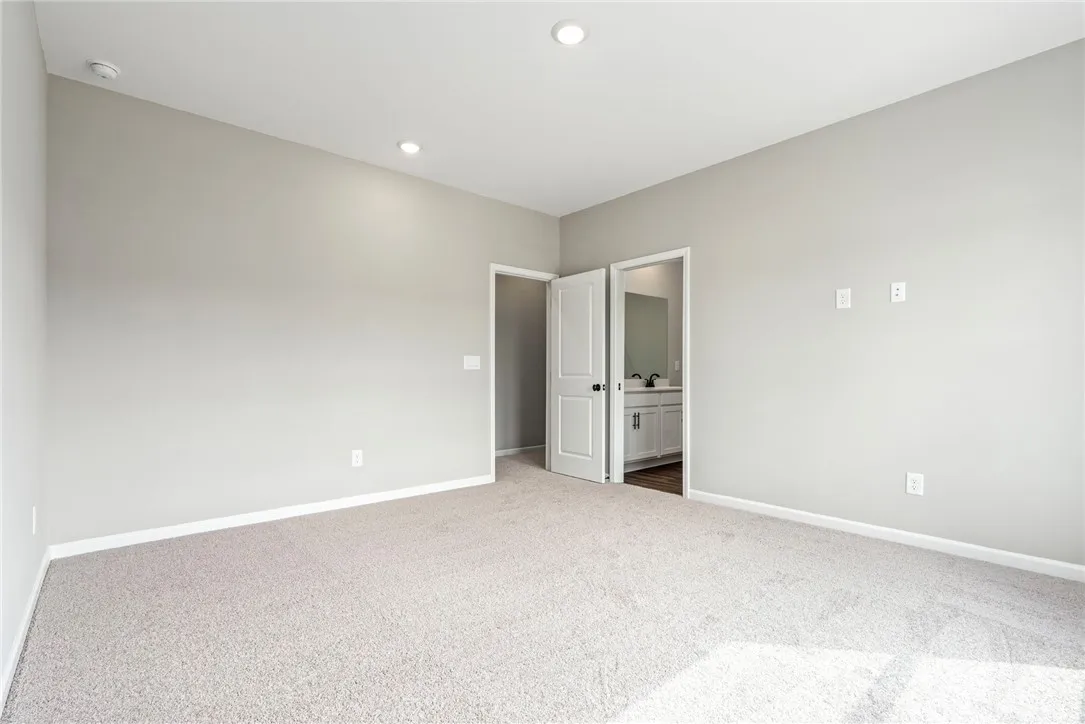 Recessed lighting and soft carpeting create a comfortable atmosphere in this modern bedroom.