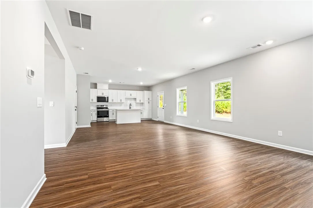 An open floorplan seamlessly connects the airy living space to a modern kitchen.