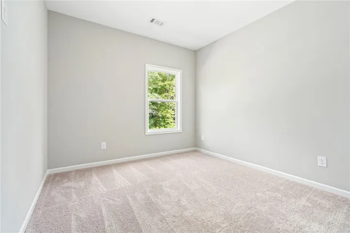 Plush carpeting and a single window looking out to nature define this versatile room.