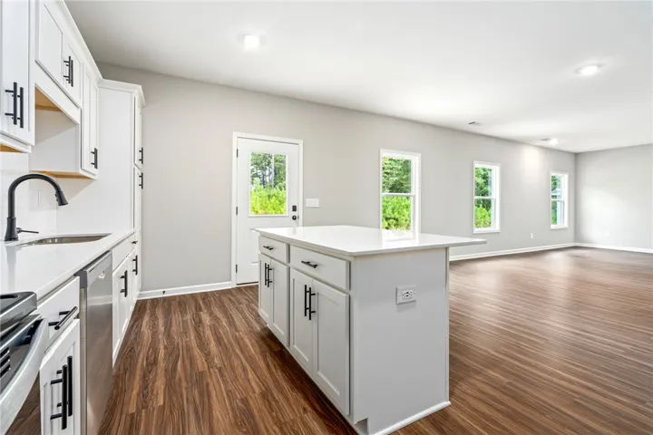 Gleaming hardwood floors flow throughout the open-concept layout connecting the kitchen and living areas.