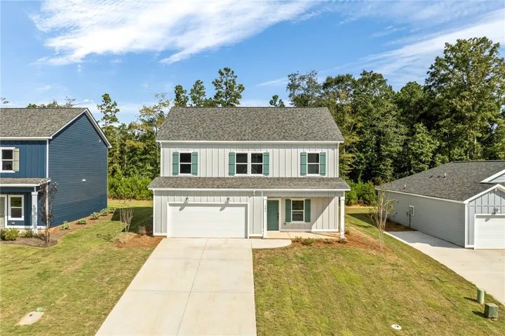 A spacious concrete driveway leads directly to an attached garage on this modern home.